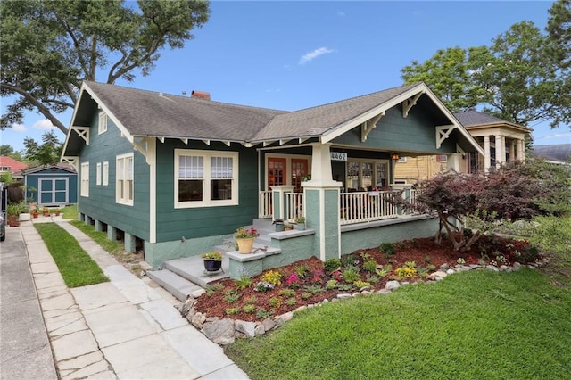 4462 Lafaye St, New Orleans, LA 70122 - view of front of home featuring a front lawn, roof with shingles, a porch, and a chimney