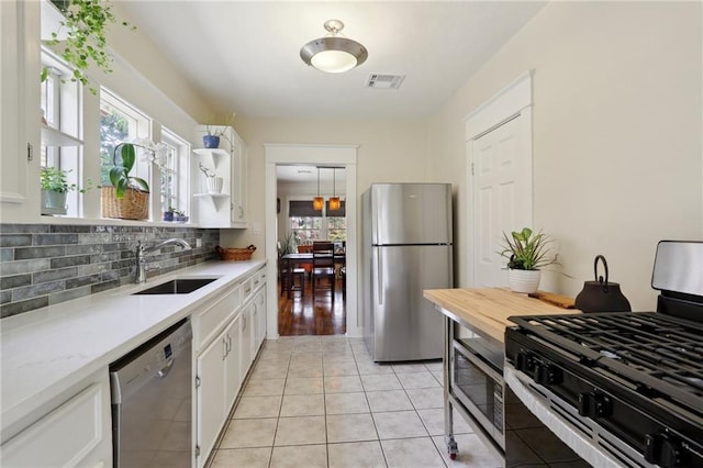 4462 Lafaye St, New Orleans, LA 70122 - kitchen with appliances with stainless steel finishes, a sink, white cabinetry, and decorative backsplash