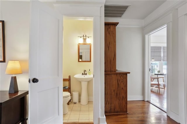 4462 Lafaye St, New Orleans, LA 70122 - half bath featuring toilet, wood finished floors, a sink, and baseboards