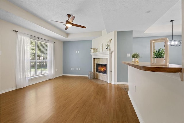 101 Sugar Mill Dr, Slidell, LA 70458 - unfurnished living room with wood finished floors, a textured ceiling, a ceiling fan, a fireplace, and baseboards