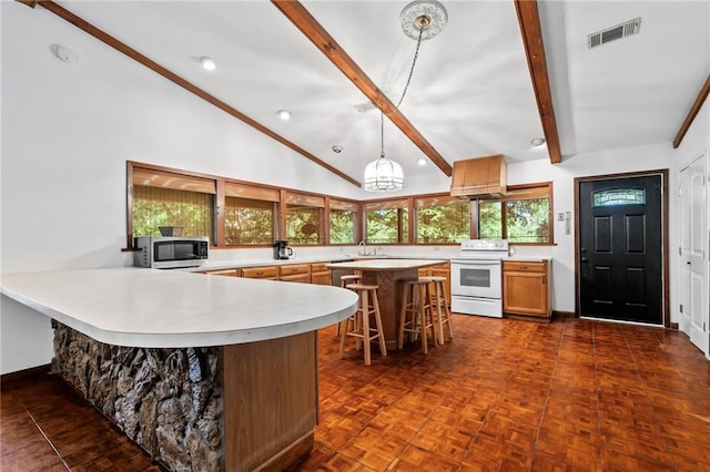 10152 Lawrence Rd, Hammond, LA 70403 - kitchen with electric range, stainless steel microwave, light countertops, a breakfast bar area, and a peninsula