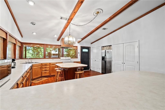 10152 Lawrence Rd, Hammond, LA 70403 - kitchen featuring stainless steel fridge, range with electric cooktop, a sink, light countertops, and decorative light fixtures