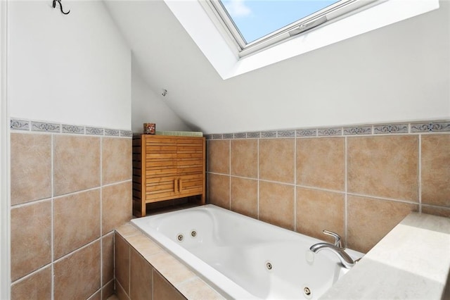 265 Cindy Lou Pl, Mandeville, LA 70448 - full bathroom with vaulted ceiling, a skylight, a jetted tub, and tile walls