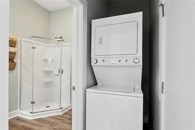 330406 Conti St, New Orleans, LA 70119 - laundry room with stacked washing machine and dryer, wood finished floors, and baseboards