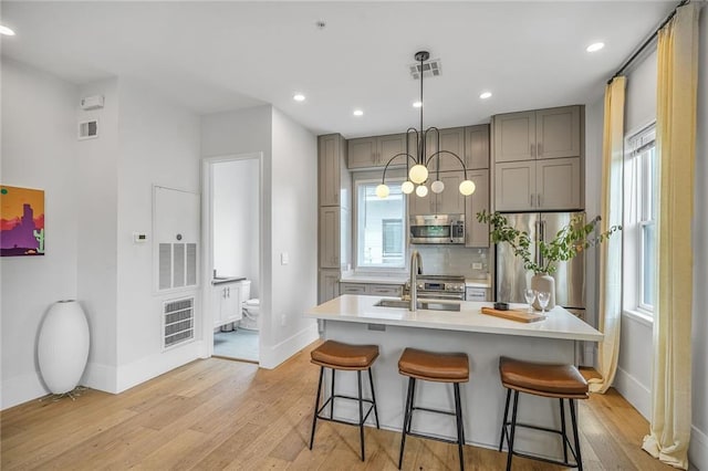 3431 Chartres St Unit 3, New Orleans, LA 70117 - kitchen with stainless steel appliances, gray cabinets, baseboards, light wood-style floors, and a sink