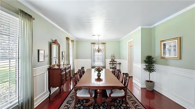 5000 Senac Dr, Metairie, LA 70003 - dining area featuring a wainscoted wall, ornamental molding, wood finished floors, and a decorative wall