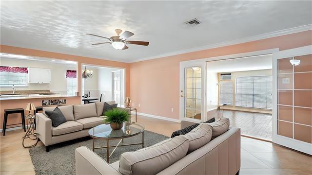 5000 Senac Dr, Metairie, LA 70003 - living room with a ceiling fan, light tile patterned floors, crown molding, a wall unit AC, and baseboards