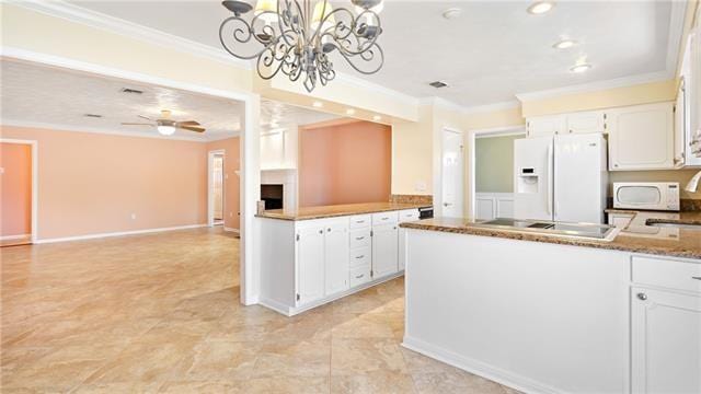 5000 Senac Dr, Metairie, LA 70003 - kitchen with white appliances, ornamental molding, a peninsula, white cabinetry, and a chandelier