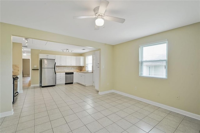 711921 Marshal Foch St, New Orleans, LA 70124 - kitchen with stainless steel appliances, decorative backsplash, a sink, ceiling fan, and baseboards