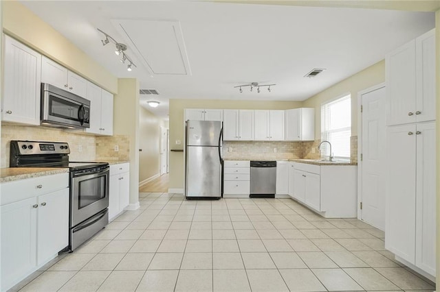 711921 Marshal Foch St, New Orleans, LA 70124 - kitchen featuring appliances with stainless steel finishes, track lighting, a sink, and tasteful backsplash