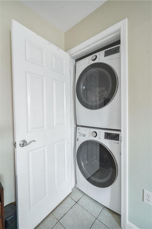 711921 Marshal Foch St, New Orleans, LA 70124 - laundry area featuring stacked washer / dryer and light tile patterned flooring