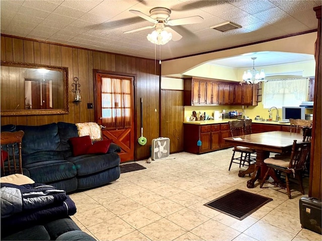 3754 Roman St, Metairie, LA 70001 - living room with a chandelier, healthy amount of natural light, ceiling fan, wooden walls, and arched walkways