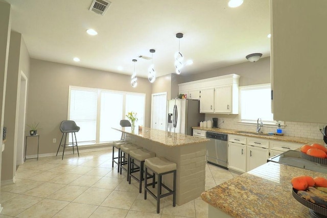 14370 Hickory Dr, Ponchatoula, LA 70454 - kitchen featuring stainless steel appliances, a sink, decorative backsplash, light tile patterned floors, and a center island