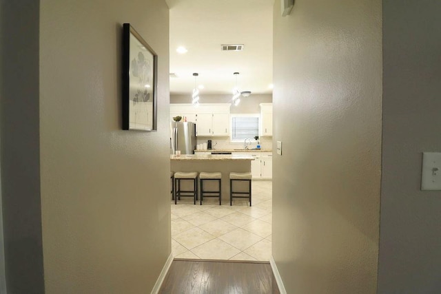 14370 Hickory Dr, Ponchatoula, LA 70454 - corridor with baseboards, a sink, a textured wall, and light wood-type flooring