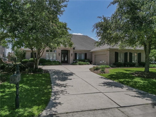 2044 S Lakeshore Blvd, Slidell, LA 70461 - view of front of home featuring brick siding, an attached garage, a front yard, and concrete driveway