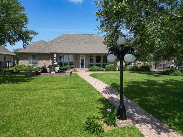 2044 S Lakeshore Blvd, Slidell, LA 70461 - rear view of house with a yard, a patio area, brick siding, and a shingled roof