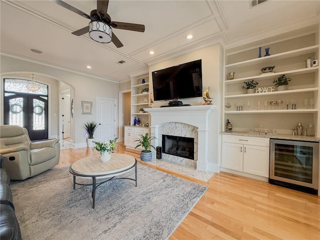 2044 S Lakeshore Blvd, Slidell, LA 70461 - living room featuring wine cooler, ornamental molding, bar area, light wood-style flooring, and a ceiling fan