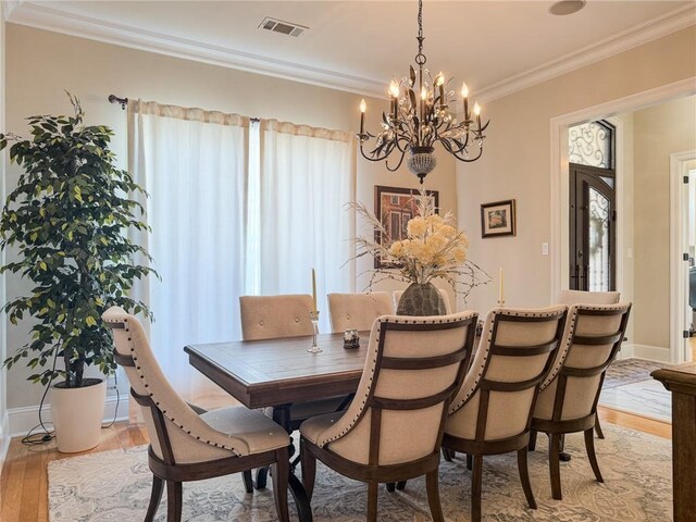 2044 S Lakeshore Blvd, Slidell, LA 70461 - dining area featuring a chandelier, light wood finished floors, crown molding, and baseboards