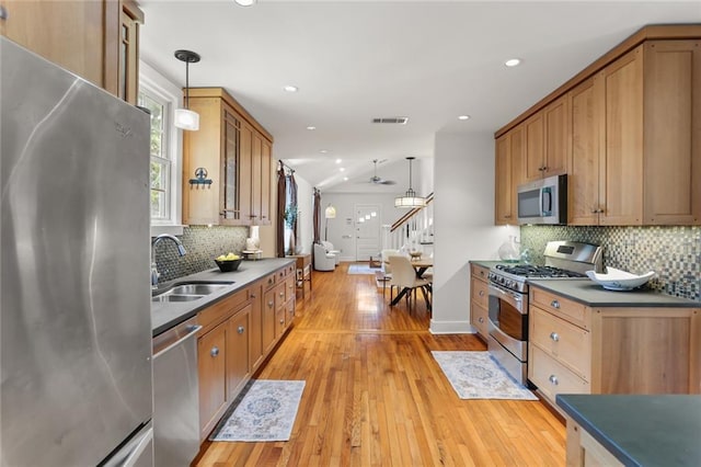 918 Harmony St, New Orleans, LA 70115 - kitchen with stainless steel appliances, a sink, backsplash, ceiling fan, and hanging light fixtures