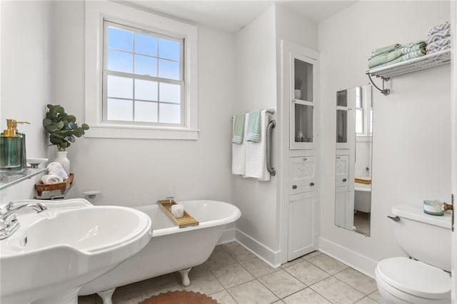 918 Harmony St, New Orleans, LA 70115 - full bathroom featuring a sink, tile patterned floors, a freestanding tub, baseboards, and toilet
