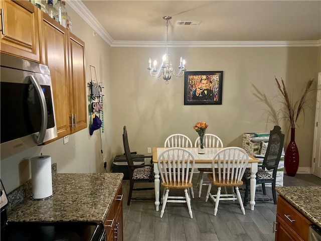 1362 Brightside Ln Unit 201, Baton Rouge, LA 70820 - dining area featuring a chandelier, crown molding, wood finished floors, and baseboards