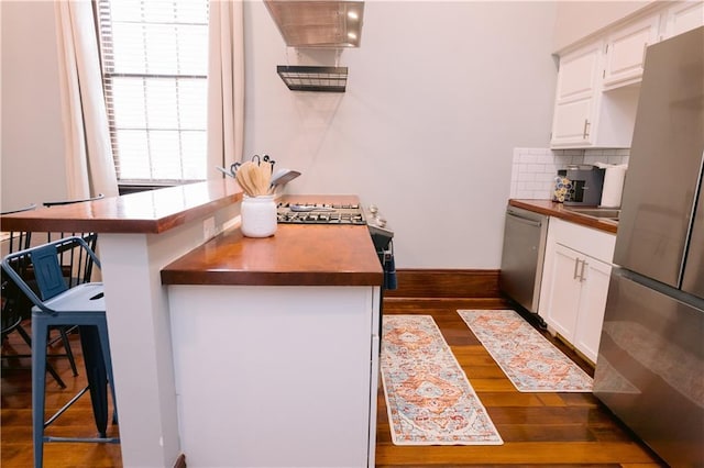 1438-40 Marais St, New Orleans, LA 70116 - kitchen featuring stainless steel appliances, wood counters, dark wood finished floors, and tasteful backsplash