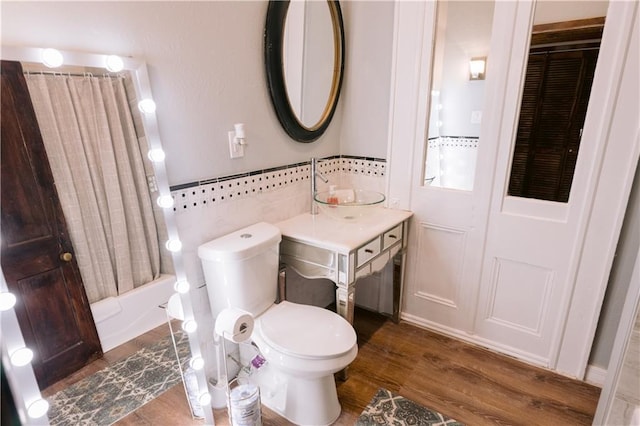 1438-40 Marais St, New Orleans, LA 70116 - bathroom featuring wood finished floors, toilet, shower / bathtub combination with curtain, and tile walls