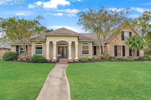 113 Kasey St, Slidell, LA 70458 - mediterranean / spanish house with a front yard, a shingled roof, stucco siding, and brick siding