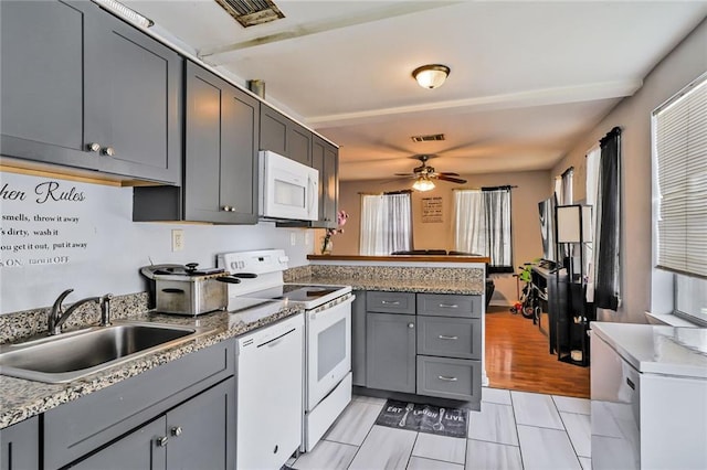 6223 Wainwright Dr, New Orleans, LA 70122 - kitchen with white appliances, a sink, a peninsula, and gray cabinetry