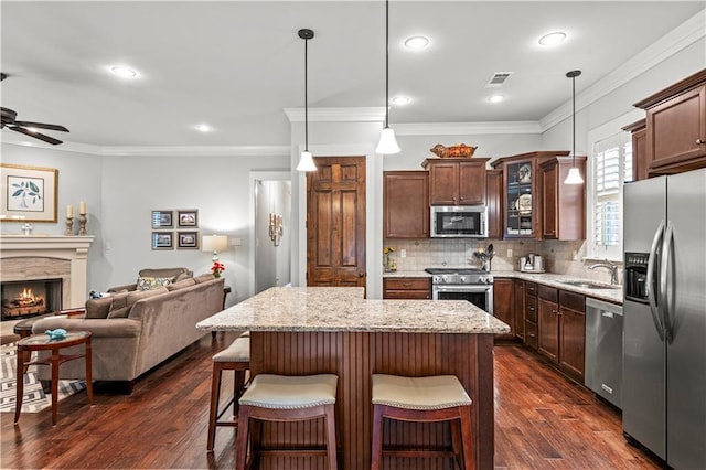 789 Rue St Germain St, Covington, LA 70433 - kitchen featuring stainless steel appliances, open floor plan, a sink, glass insert cabinets, and ceiling fan