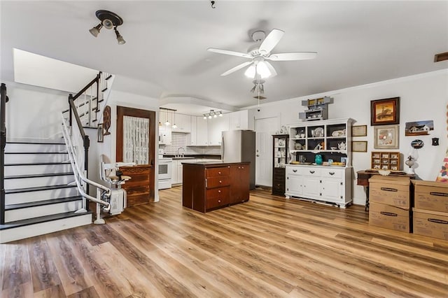 4525 Beau Lac Ln, Metairie, LA 70002 - kitchen featuring white cabinetry, a ceiling fan, a kitchen island, backsplash, and range