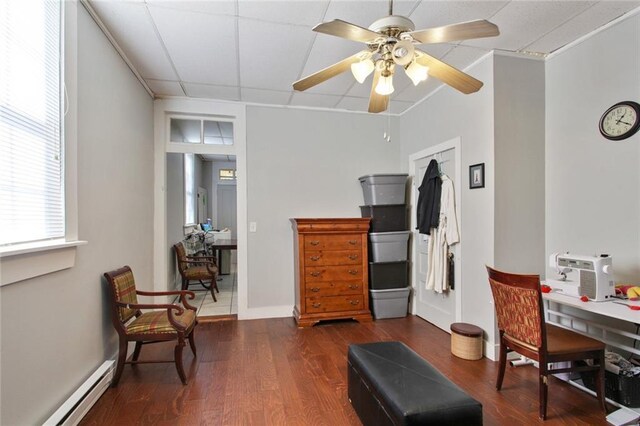 232830 Frenchmen St, New Orleans, LA 70119 - living room with baseboard heating, wood finished floors, ceiling fan, and baseboards