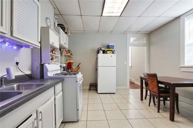 232830 Frenchmen St, New Orleans, LA 70119 - kitchen featuring white appliances, dark countertops, a drop ceiling, a sink, and light tile patterned flooring