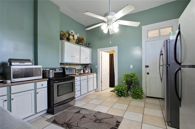 232830 Frenchmen St, New Orleans, LA 70119 - kitchen with stainless steel appliances, white cabinets, light tile patterned flooring, a towering ceiling, and ceiling fan