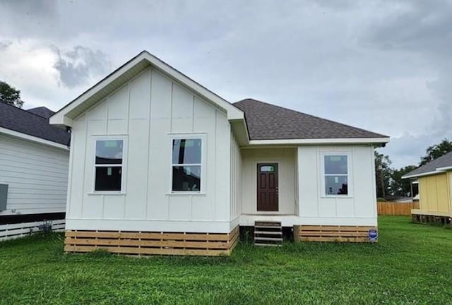 220 Trudeau Dr, Metairie, LA 70003 - back of property featuring board and batten siding, a lawn, and roof with shingles
