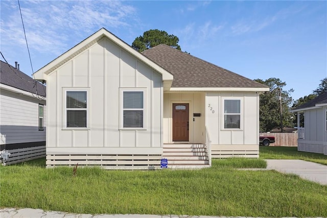 220 Trudeau Dr, Metairie, LA 70003 - view of front of property with board and batten siding, a front lawn, and a shingled roof