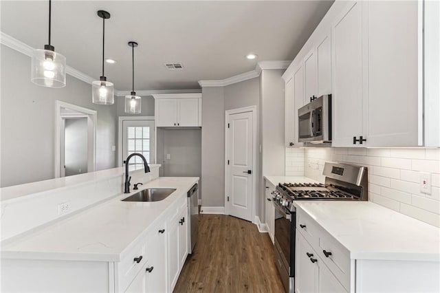 220 Trudeau Dr, Metairie, LA 70003 - kitchen with appliances with stainless steel finishes, a sink, white cabinetry, decorative backsplash, and recessed lighting