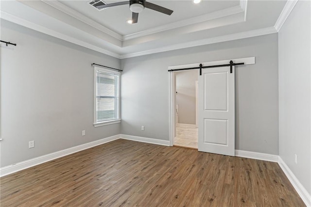 220 Trudeau Dr, Metairie, LA 70003 - unfurnished bedroom featuring a barn door, a raised ceiling, wood finished floors, ornamental molding, and recessed lighting