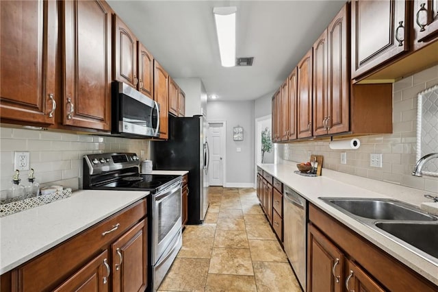 47261 Eldridge Magee Rd, Franklinton, LA 70438 - kitchen with appliances with stainless steel finishes, a sink, baseboards, decorative backsplash, and light countertops