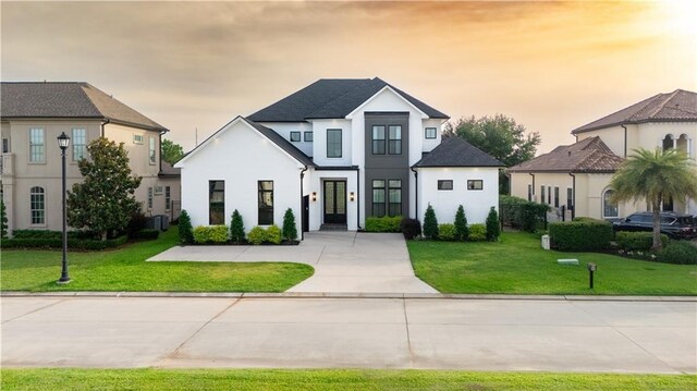25 Cycas, Kenner, LA 70065 - view of front facade featuring stucco siding, concrete driveway, a front yard, and an attached garage