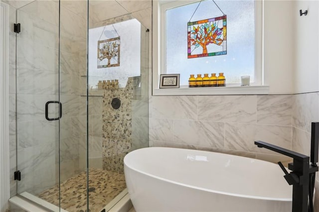 5317 Warrington Dr, New Orleans, LA 70122 - bathroom featuring a soaking tub, a stall shower, and tile walls