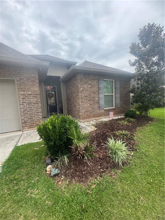 11018 Regency Ave, Hammond, LA 70403 - view of property exterior featuring brick siding, an attached garage, a yard, and driveway