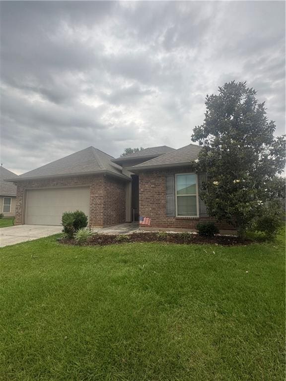 11018 Regency Ave, Hammond, LA 70403 - view of front of house with brick siding, a garage, concrete driveway, and a front lawn