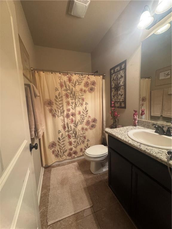 11018 Regency Ave, Hammond, LA 70403 - full bathroom with vanity, toilet, tile patterned floors, and curtained shower