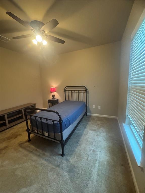11018 Regency Ave, Hammond, LA 70403 - bedroom with carpet floors, multiple windows, baseboards, and a ceiling fan