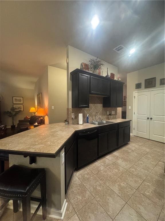 11018 Regency Ave, Hammond, LA 70403 - kitchen featuring black dishwasher, a sink, a peninsula, backsplash, and light countertops