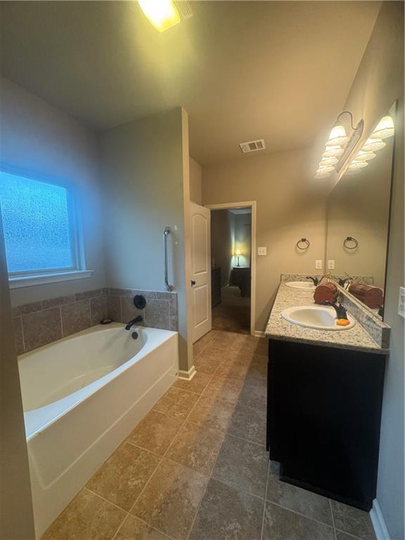 11018 Regency Ave, Hammond, LA 70403 - bathroom with double vanity, a bath, tile patterned flooring, and baseboards