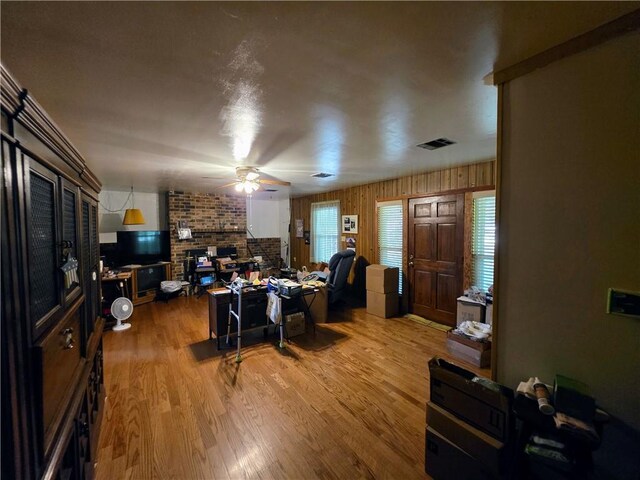 46282 Morris Rd, Hammond, LA 70401 - living area featuring ceiling fan, wood finished floors, a brick fireplace, and wooden walls