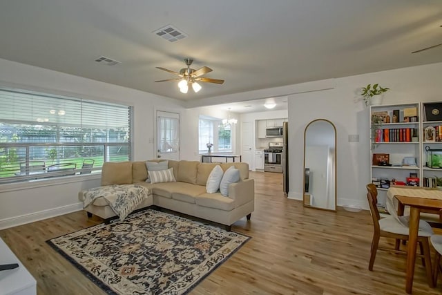 1414 Englewood Dr, Slidell, LA 70458 - living area with ceiling fan, light wood finished floors, a chandelier, and baseboards