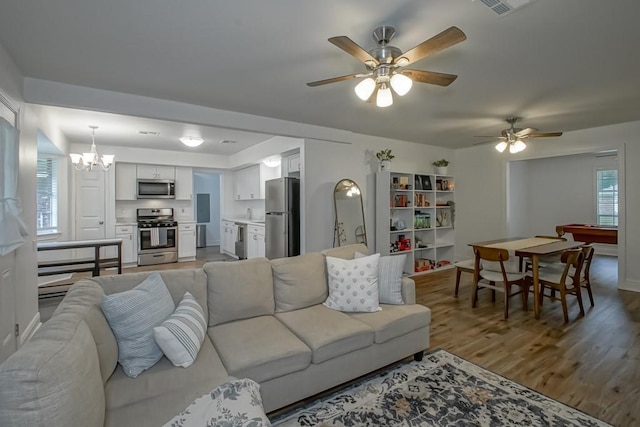 1414 Englewood Dr, Slidell, LA 70458 - living room with light wood-style flooring, ceiling fan, a chandelier, and baseboards
